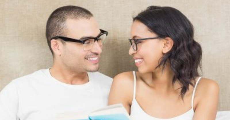 happy-couple-reading-bed-home